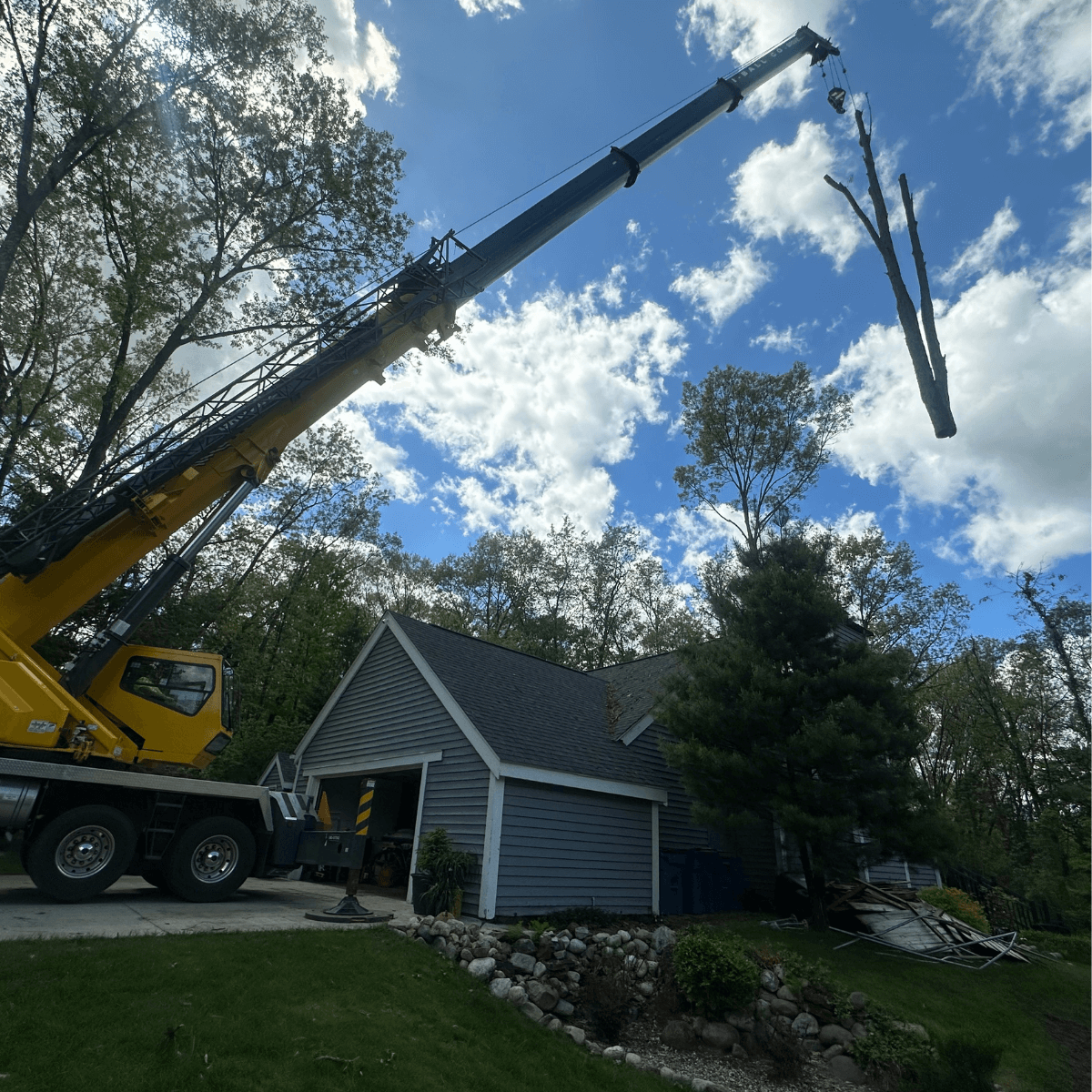 Storm-damaged tree being removed near a home in Augusta, MI