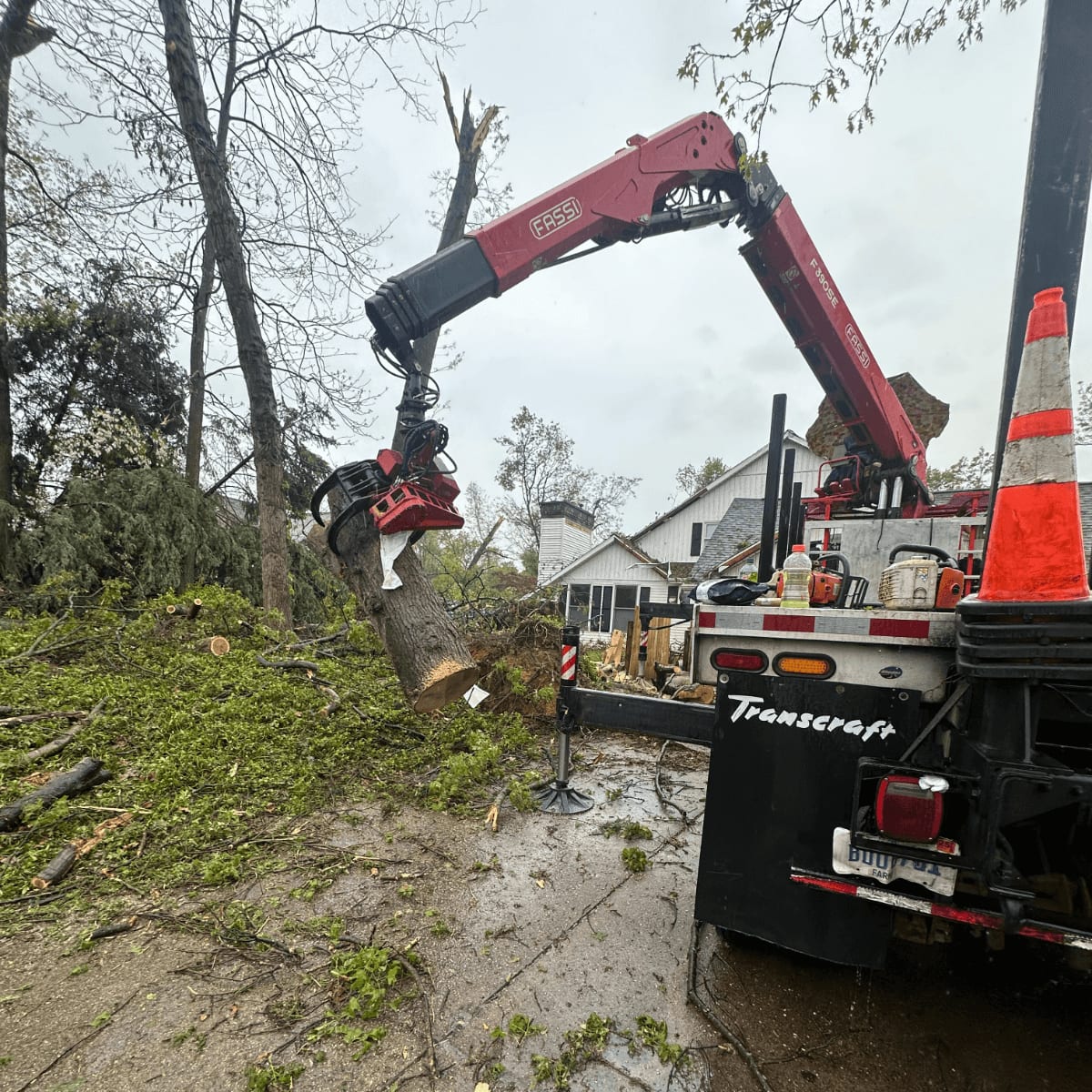 Bucket Truck Brawner's Tree Service bucket truck positioned next to a tall oak during a trimming job in Kalamazoo, MI.