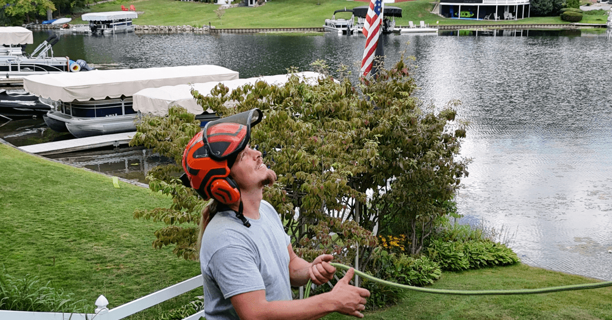 Our Tree service crew cutting down storm-damaged oak in Scotts, MI yard